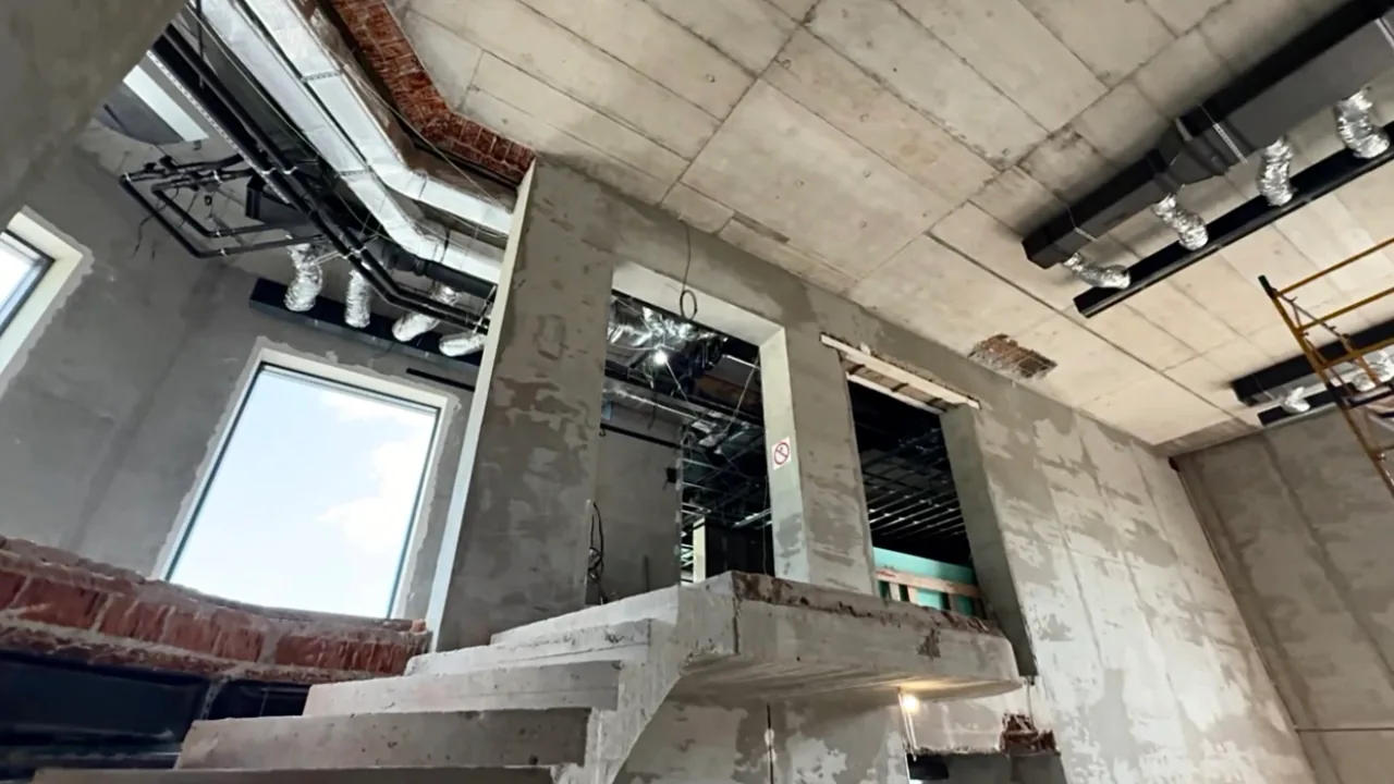 Чорновий монтаж магістральних повітропроводів і відгалужень вентиляції під бетонною стелею приватного будинку.