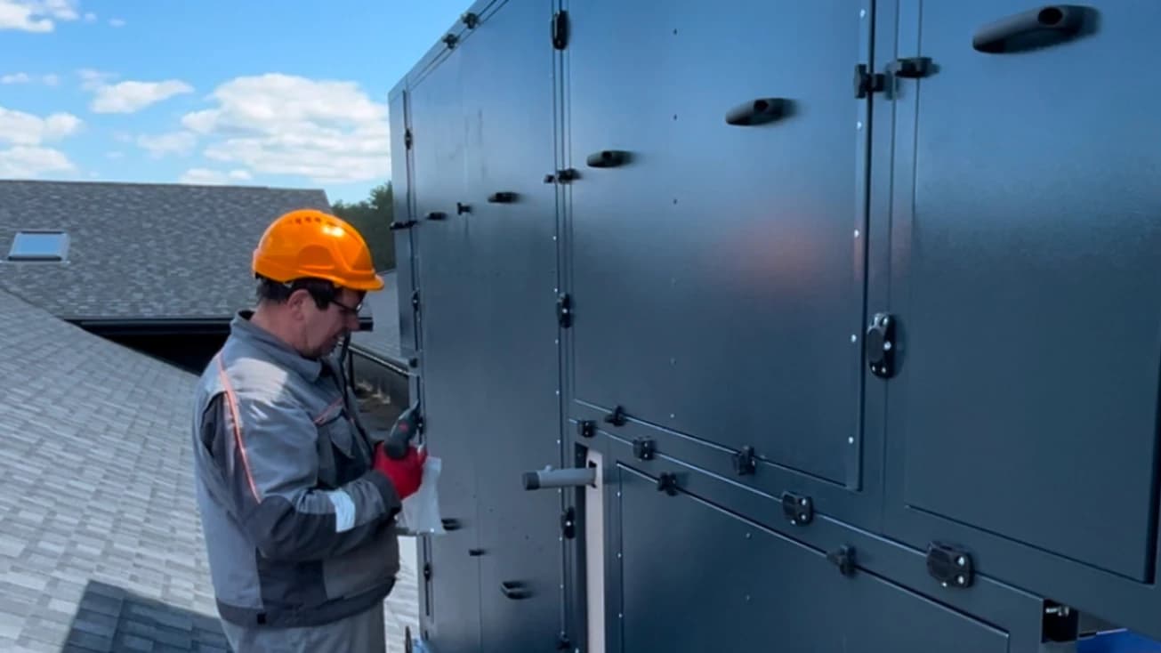 Фахівець VENTALL виконує обслуговування вентиляційного обладнання на об’єкті.