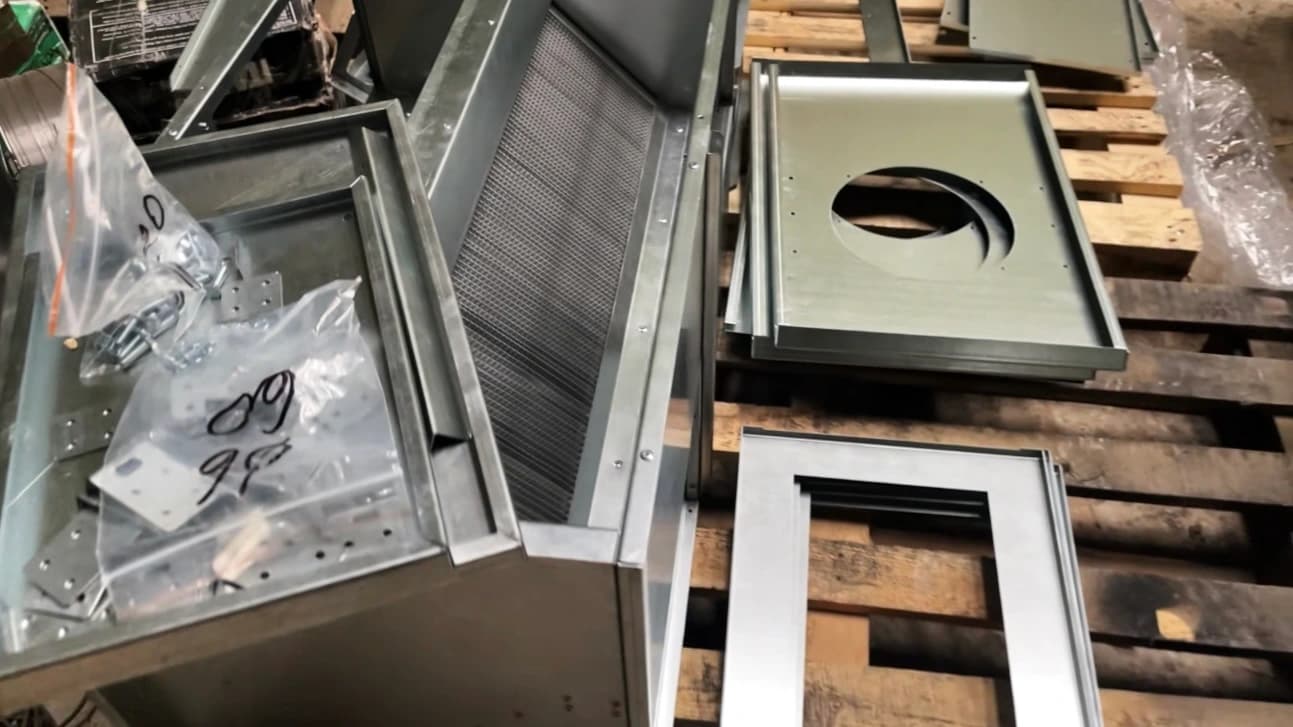 Металеві деталі, кріплення та елементи корпусу вентиляційного обладнання на виробничій ділянці.